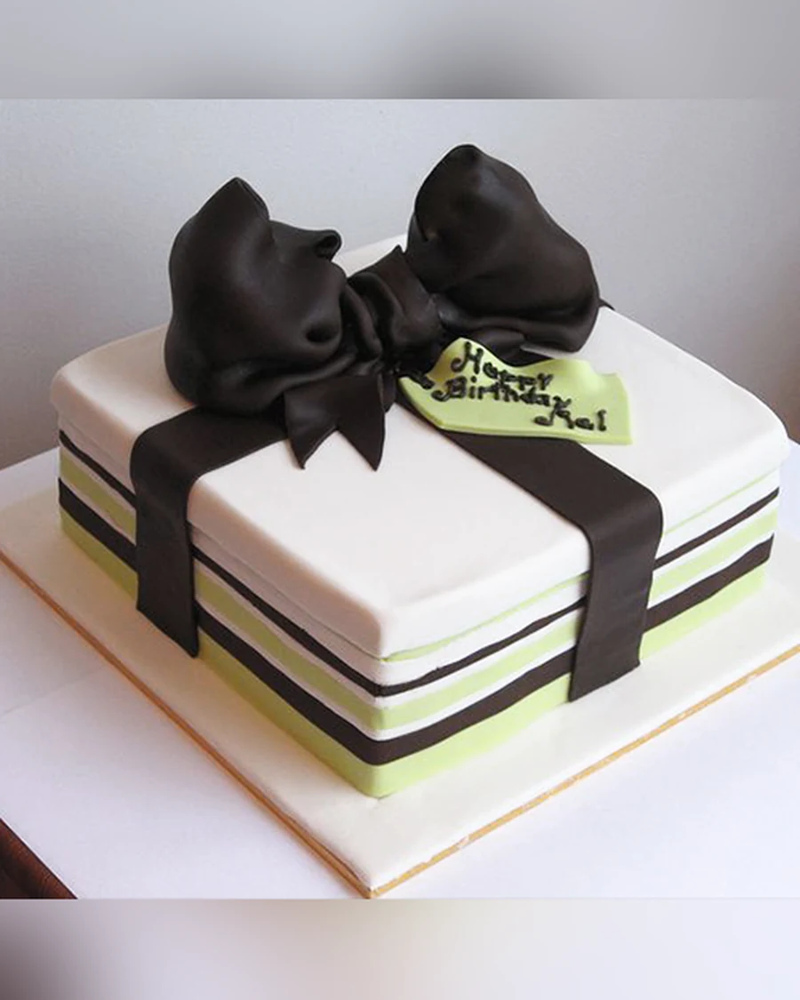 Kue fondant putih dengan pita cokelat