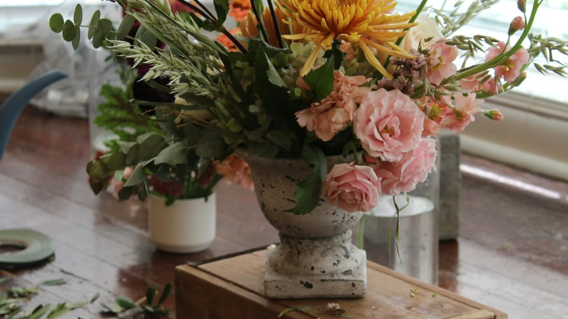 Rangkaian bunga segar di atas meja kayu dekat jendela, di meja kerja florist